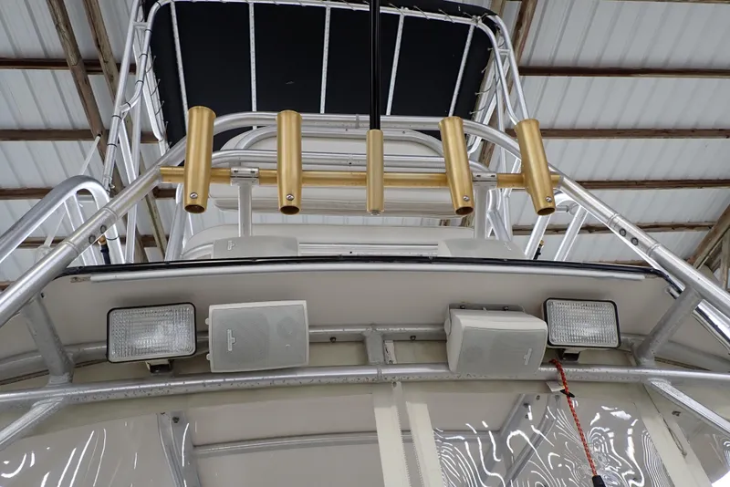 Slide: The Image of 1999 Albemarle 320 Express boat with gold rod holders and mounted lights in a covered area. - 41