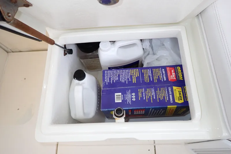 Slide: The Image of Storage compartment on a 1999 Albemarle 320 Express boat with cleaning supplies. - 48