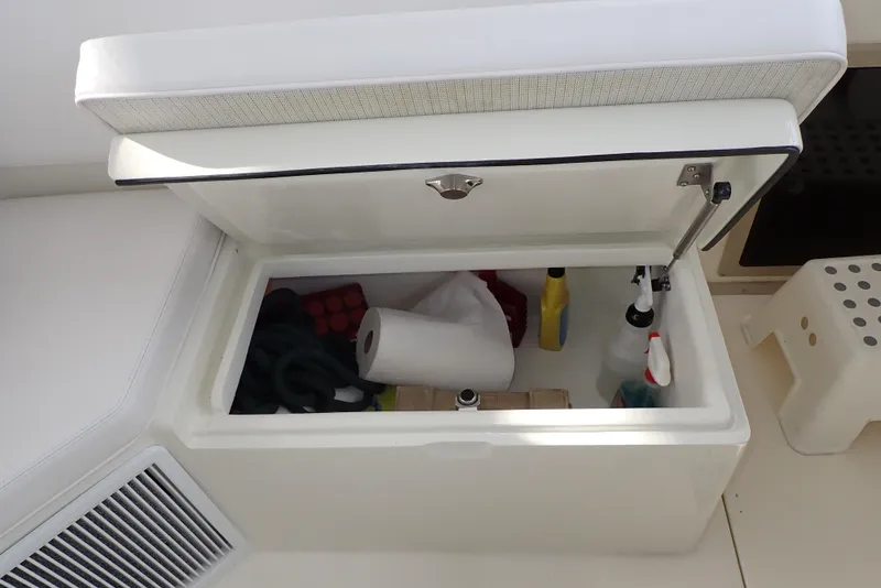 Slide: The Image of Storage compartment on a 1999 Albemarle 320 Express boat, containing cleaning supplies and paper towels. - 49