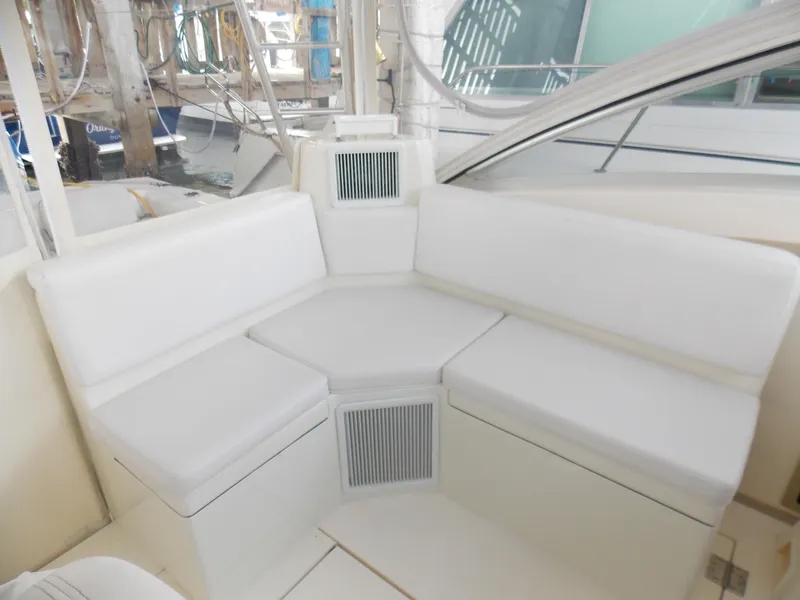 Slide: The Image of 1999 Albemarle 320 Express boat interior with white cushioned seating. - 6