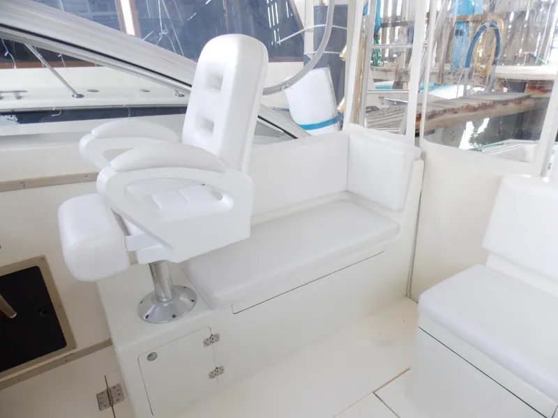 Slide: The Image of 1999 Albemarle 320 Express boat interior with white seating and helm chair. - 8