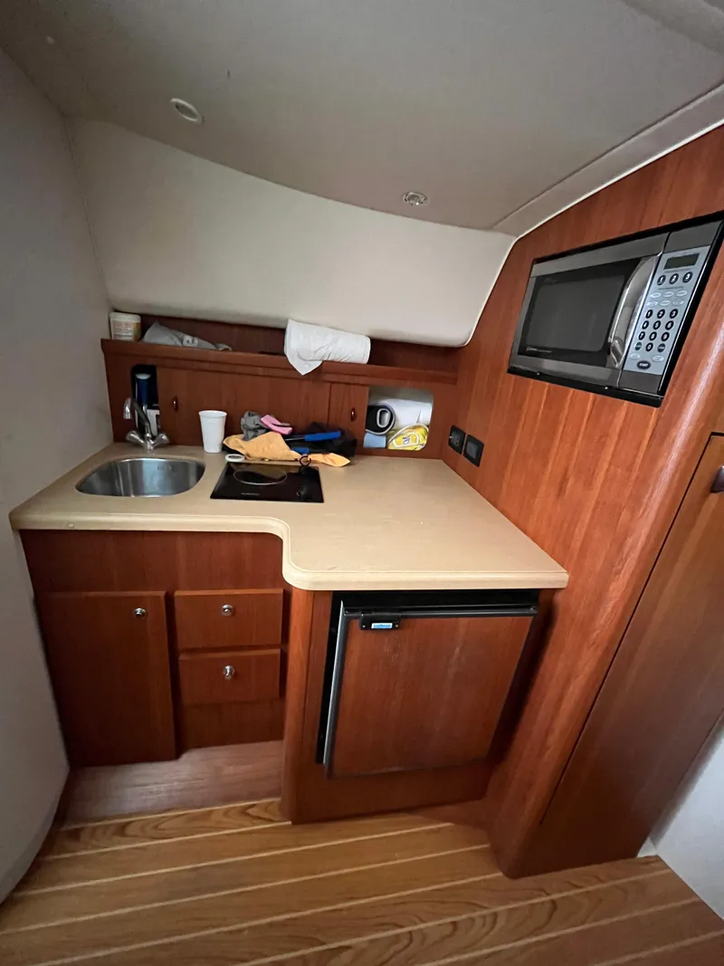 Slide: The Image of 2004 Tiara Yachts Classic kitchenette with sink, microwave, and mini fridge. - 4