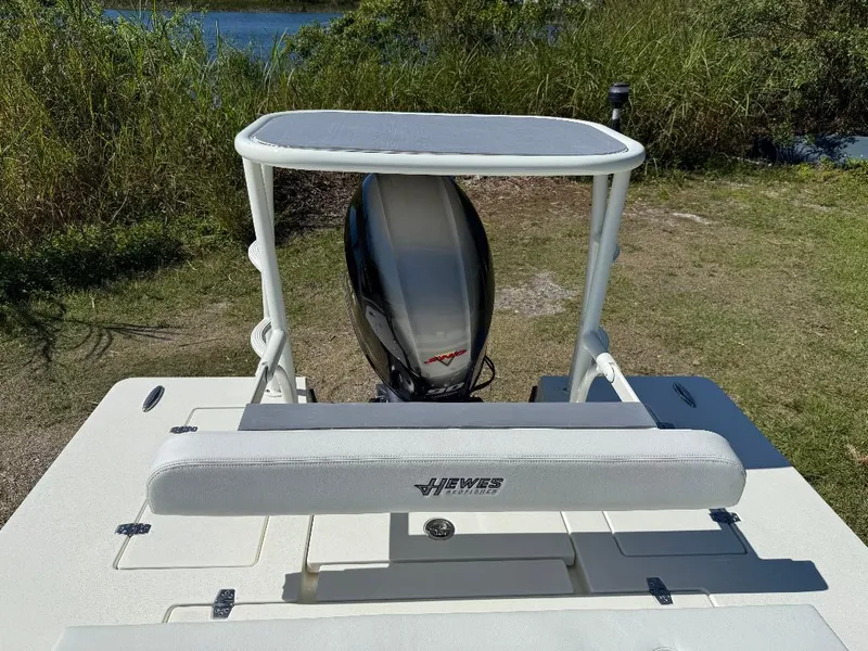 Slide: The Image of 2025 Hewes 16 Redfisher boat with motor, parked on grassy area near water. - 12