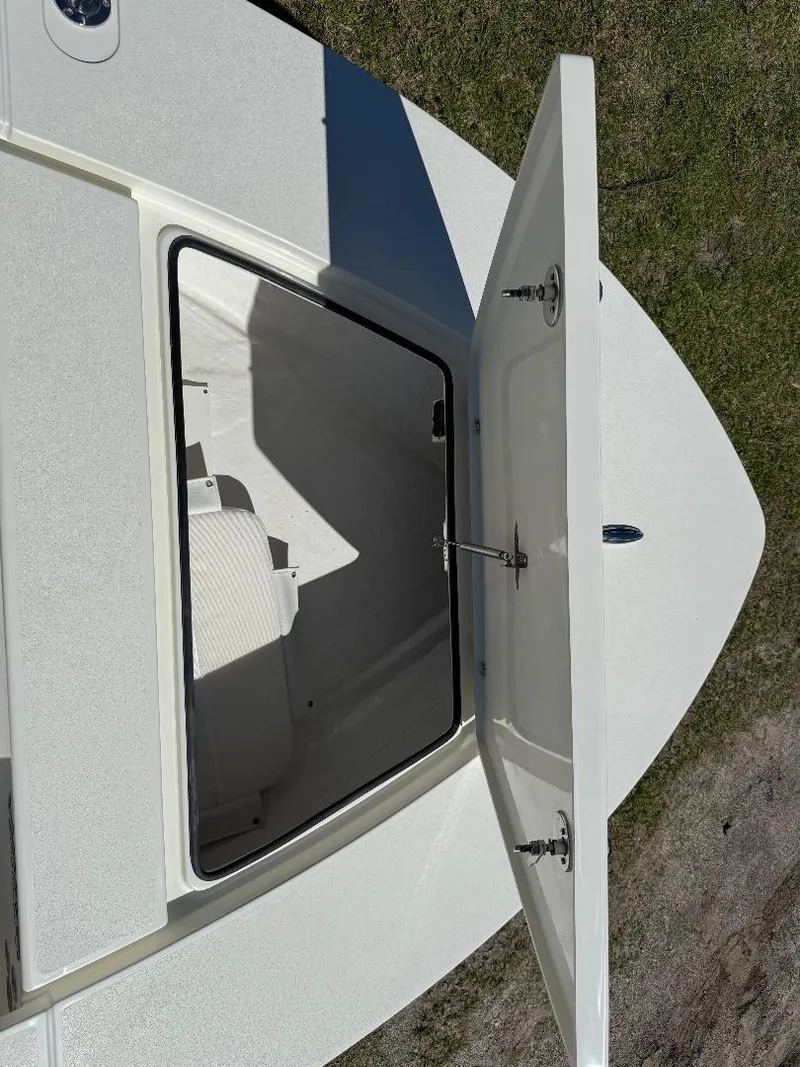 Slide: The Image of 2025 Hewes 16 Redfisher boat storage compartment open, showing interior details. - 15