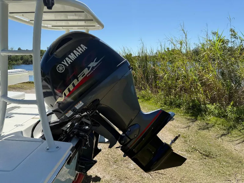 Slide: The Image of 2025 Hewes 16 Redfisher with Yamaha VMAX outboard motor, parked near a grassy lakeside. - 17