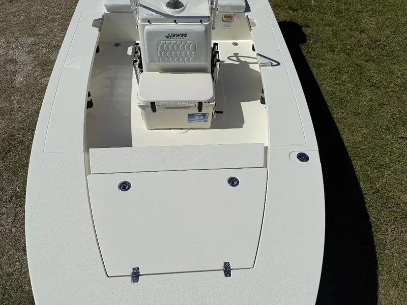 Slide: The Image of 2025 Hewes 16 Redfisher boat, white deck, seating, and storage compartments, on grass. - 19