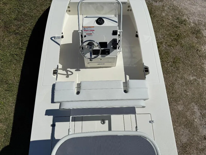 Slide: The Image of 2025 Hewes 16 Redfisher boat interior with steering console, white seating, and clean deck. - 23