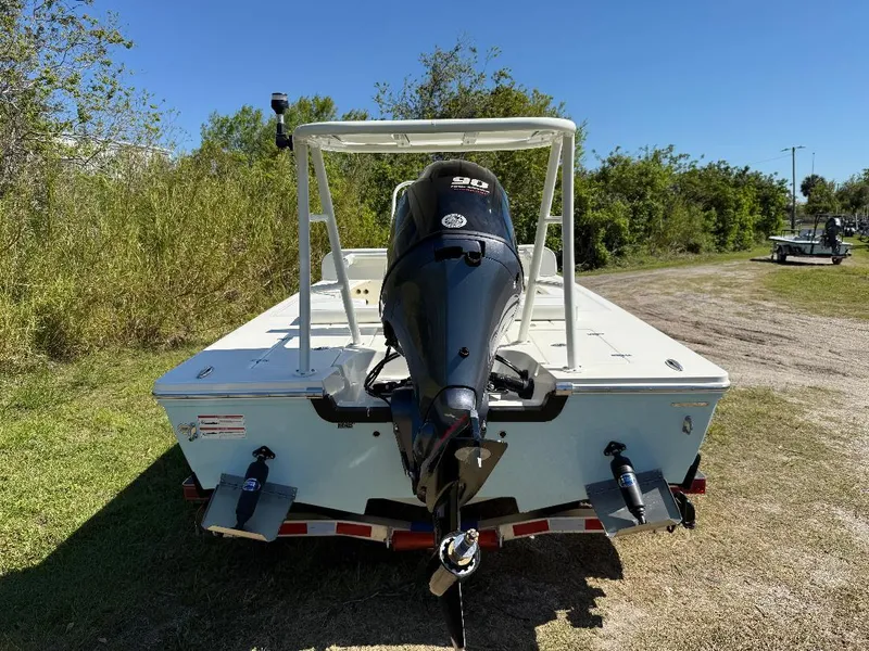 Slide: The Image of 2025 Hewes 16 Redfisher boat with outboard motor, parked on grass. - 26