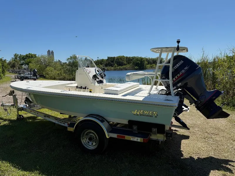 Slide: The Image of 2025 Hewes 16 Redfisher boat on trailer by a lake, sunny day. - 29