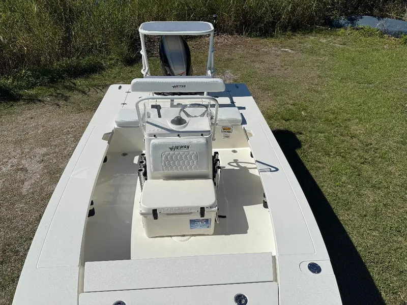 Slide: The Image of 2025 Hewes 16 Redfisher boat on grass, showcasing seating and console. - 3