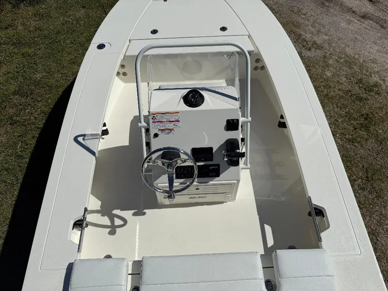 Slide: The Image of 2025 Hewes 16 Redfisher boat interior with steering console and seating, viewed from above. - 8