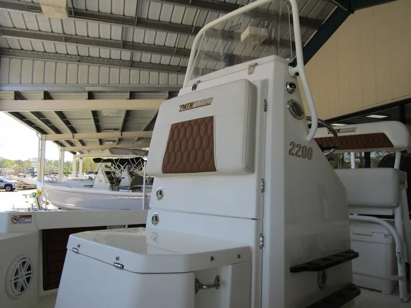 Slide: The Image of 2025 Pathfinder TRS 2200 boat interior with brown and white seating under a metal roof. - 7