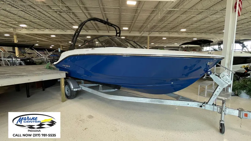 Slide: The Image of 2025 Bayliner V20i boat in showroom, blue hull, on trailer, Marine Center Indiana. - 15