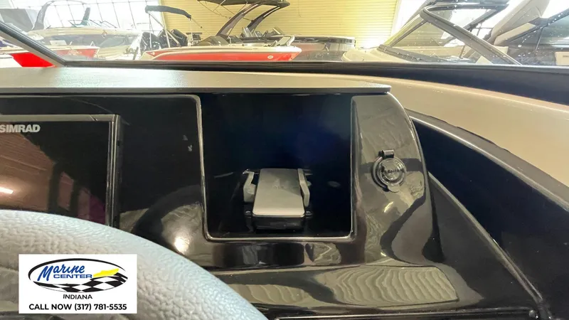 Slide: The Image of Dashboard of 2025 Bayliner V20i boat with Simrad display and storage compartment. - 2