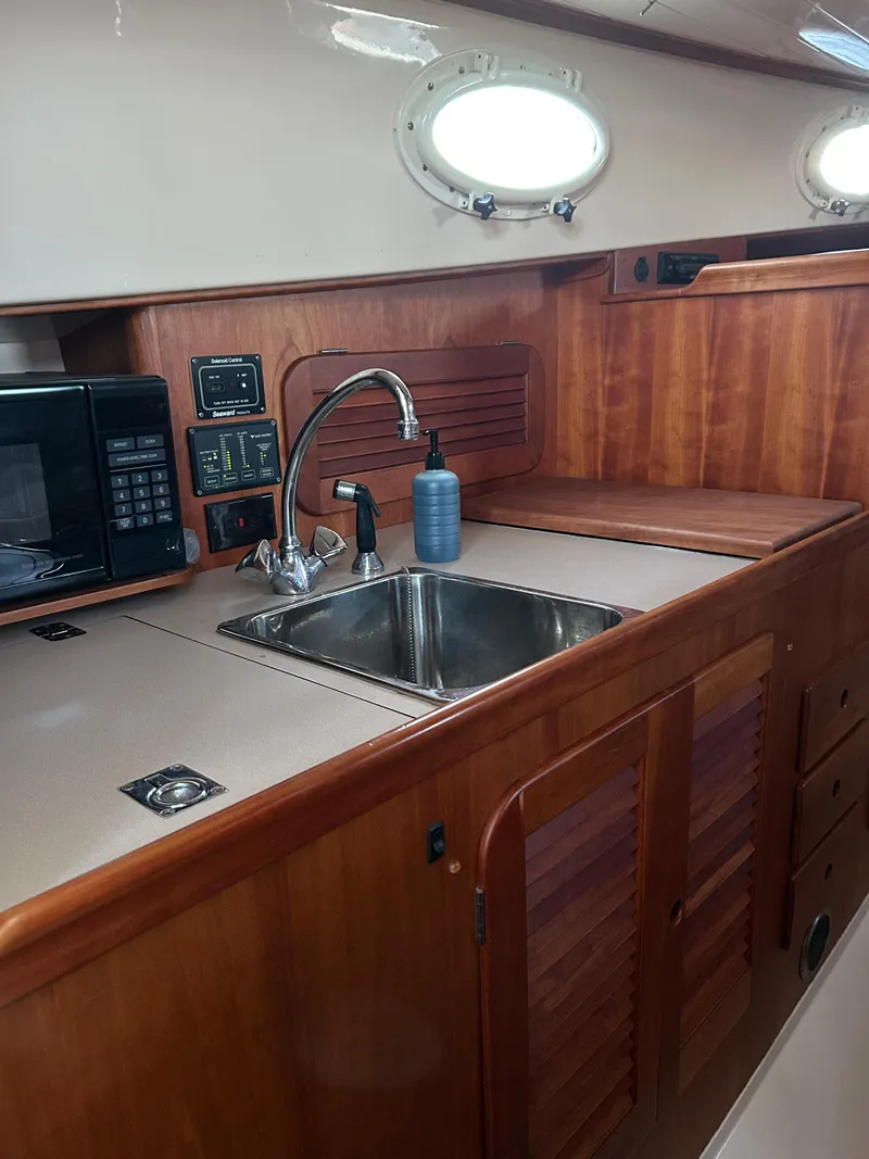 Slide: The Image of 2001 Hinckley Classic 36 Picnic Boat interior with wooden cabinetry and stainless steel sink. - 33
