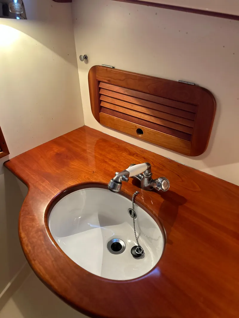 Slide: The Image of 2001 Hinckley Classic 36 Picnic Boat interior with wooden sink area. - 45