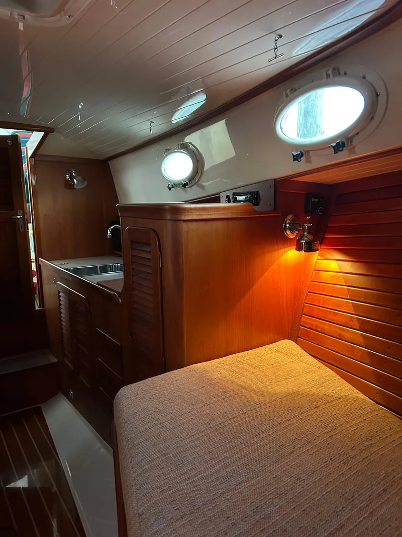 Slide: The Image of Interior of 2001 Hinckley Classic 36 Picnic Boat with wood paneling and cozy lighting. - 36