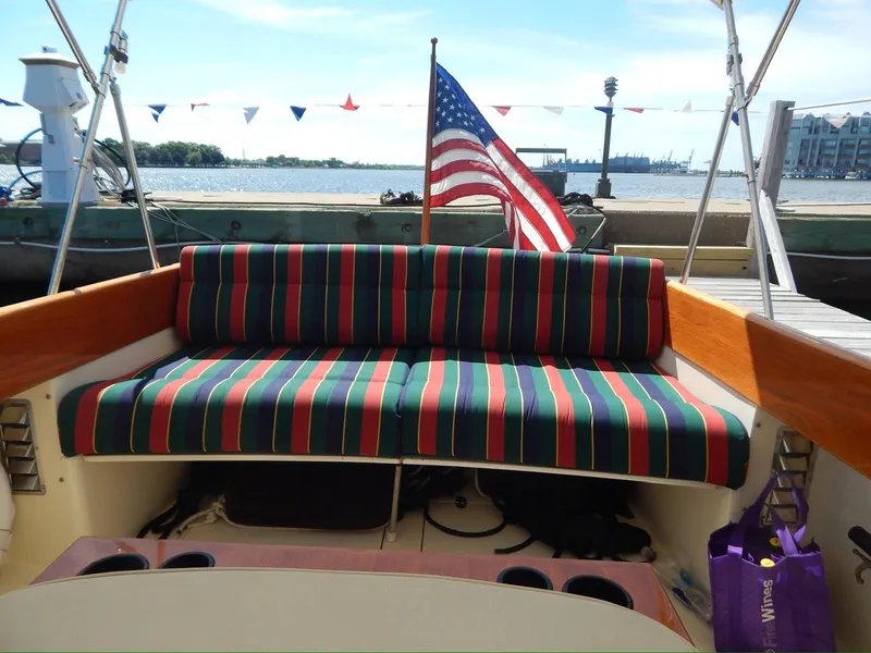 Slide: The Image of 2001 Hinckley Classic 36 Picnic Boat with striped seating and American flag at dock. - 6