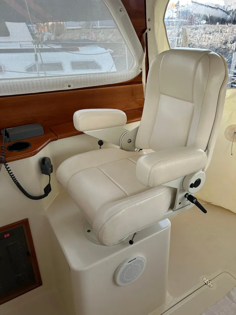 Slide: The Image of Captain's chair in 2001 Hinckley Classic 36 Picnic Boat cockpit, featuring beige leather upholstery. - 18