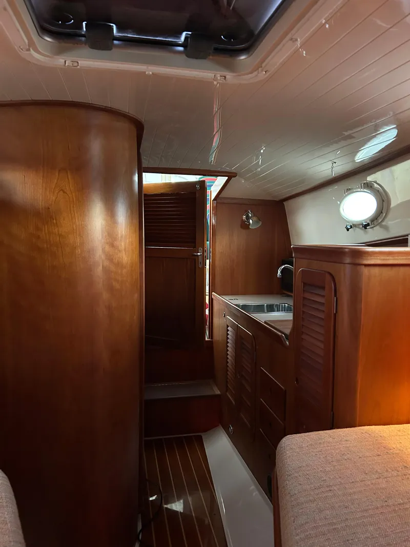 Slide: The Image of Interior of 2001 Hinckley Classic 36 Picnic Boat with wooden cabinetry and cozy seating. - 37
