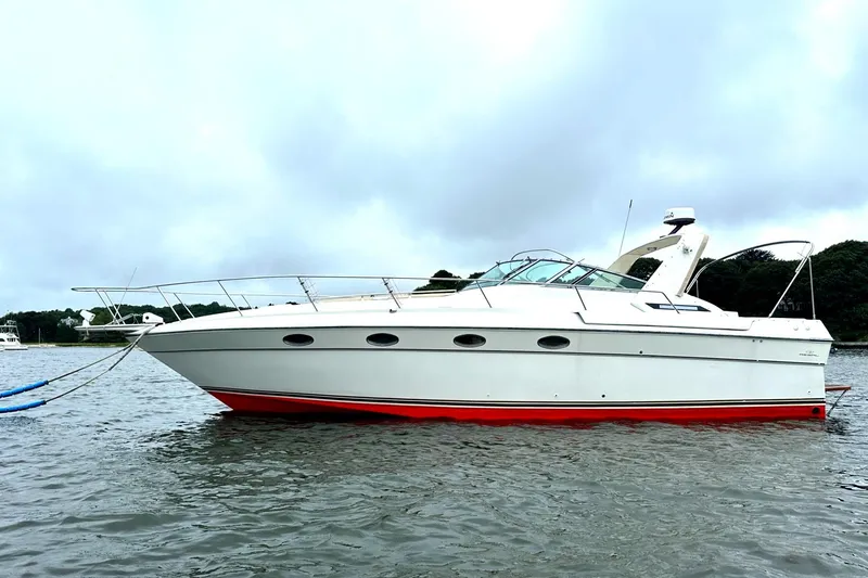 Slide: The Image of 1988 Regal 360 XL Commodore boat on water, white with red hull, updated features. - 1