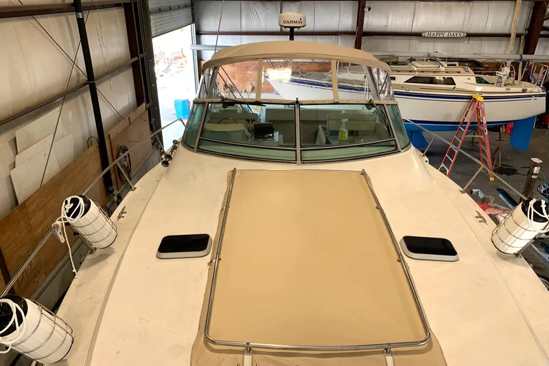 Slide: The Image of 1988 Regal 360 XL Commodore boat in storage, featuring updated design and beige cover. - 14