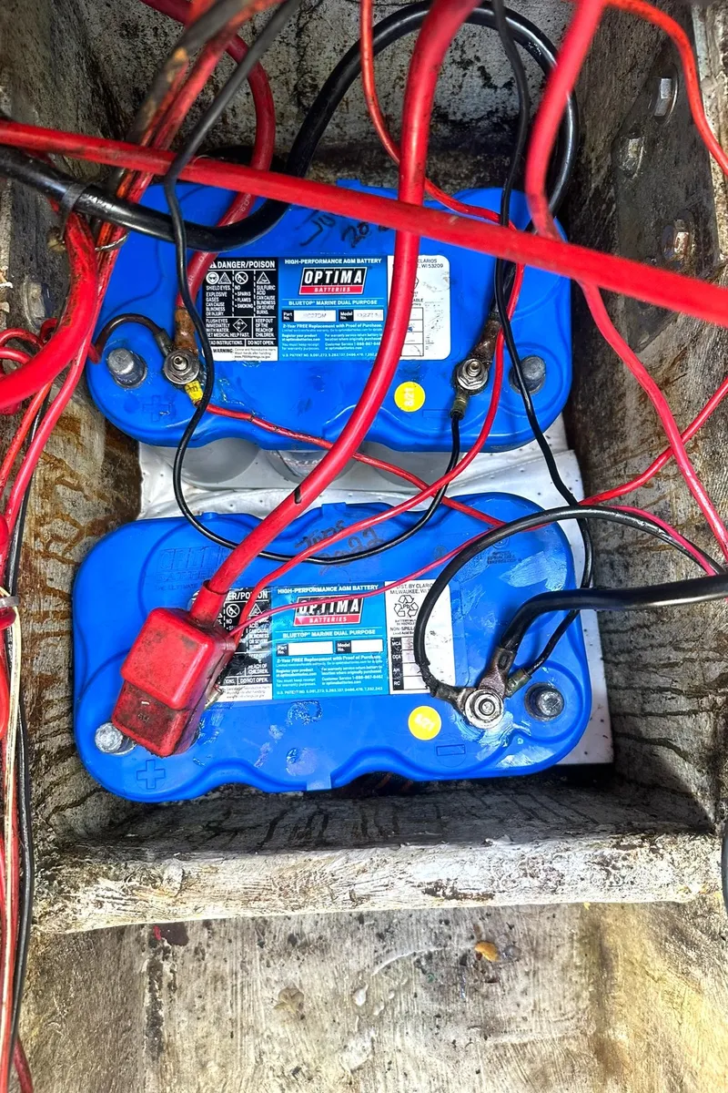Slide: The Image of Two blue Optima batteries with red and black cables in a 1988 Regal 360 XL Commodore. - 24