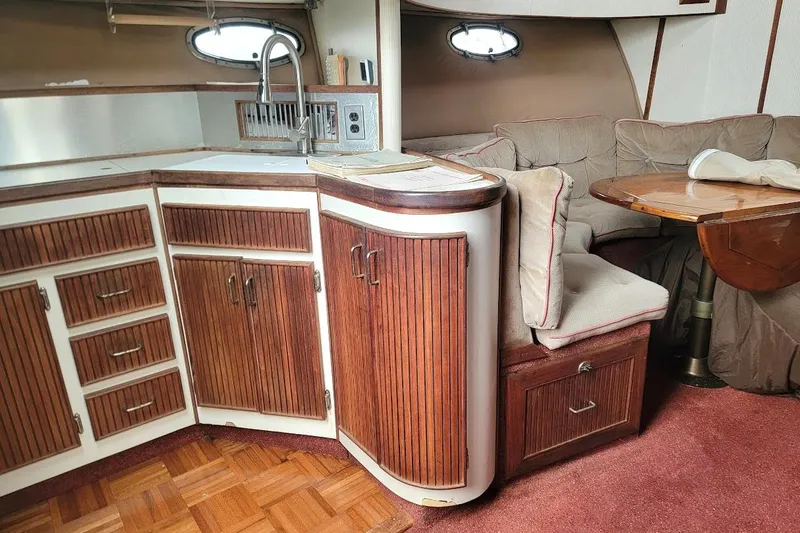 Slide: The Image of Interior of a 1988 Regal Commodore 360 yacht with wood cabinetry and cozy seating area. - 34