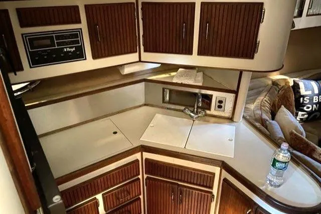 Slide: The Image of 1988 Regal 360 XL Commodore kitchen area with wood cabinets and modern updates. - 5