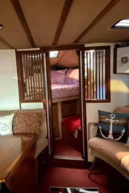 Slide: The Image of 1988 Regal 360 XL Commodore interior with cozy seating and nautical decor. - 8