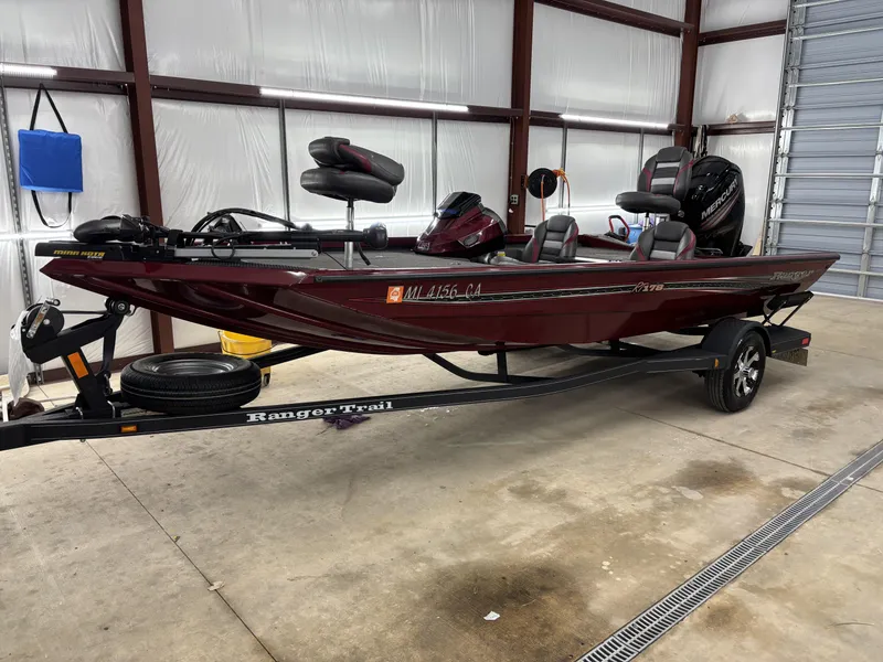 Slide: The Image of 2019 Ranger RT178 boat in a garage, maroon color, on a Ranger Trail trailer. - 8