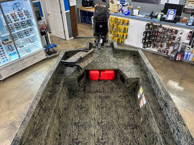 Slide: The Image of 2025 Tracker 1650 Prairie Wings Edition boat displayed in a store with accessories. - 10