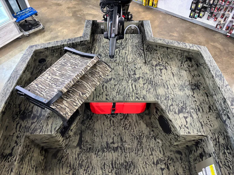 Slide: The Image of 2025 Tracker 1650 Prairie Wings Edition boat with camouflage interior and red storage compartment. - 7