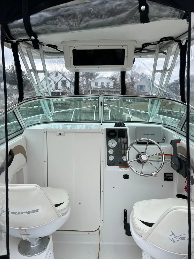Slide: The Image of 2003 Seaswirl Striper 2301 Walkaround OB boat interior with steering wheel and seating. - 11