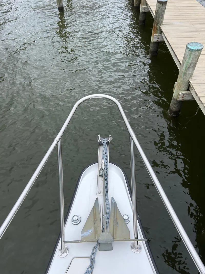 Slide: The Image of Bow of 2003 Seaswirl Striper 2301 Walkaround OB near dock, showing anchor and railing. - 13