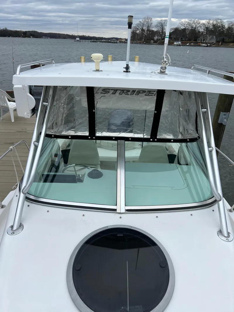 Slide: The Image of 2003 Seaswirl Striper 2301 Walkaround OB boat docked by a lake. - 14