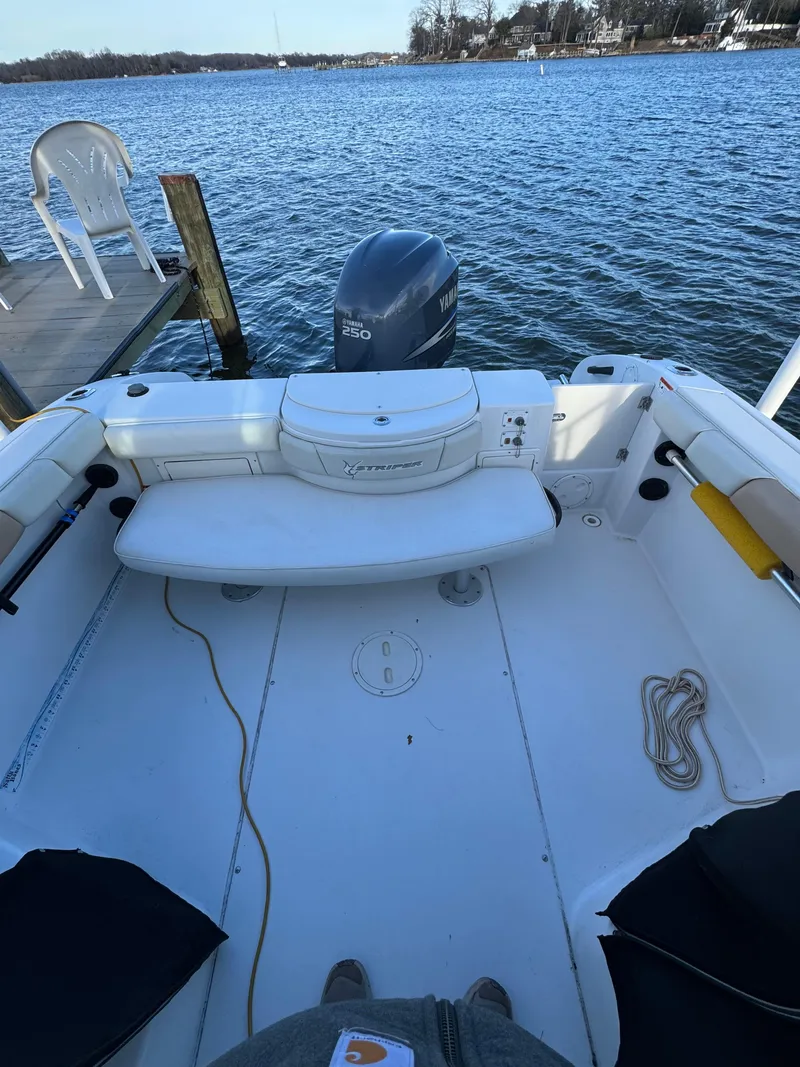 Slide: The Image of 2003 Seaswirl Striper 2301 Walkaround OB boat docked by a serene lake. - 20