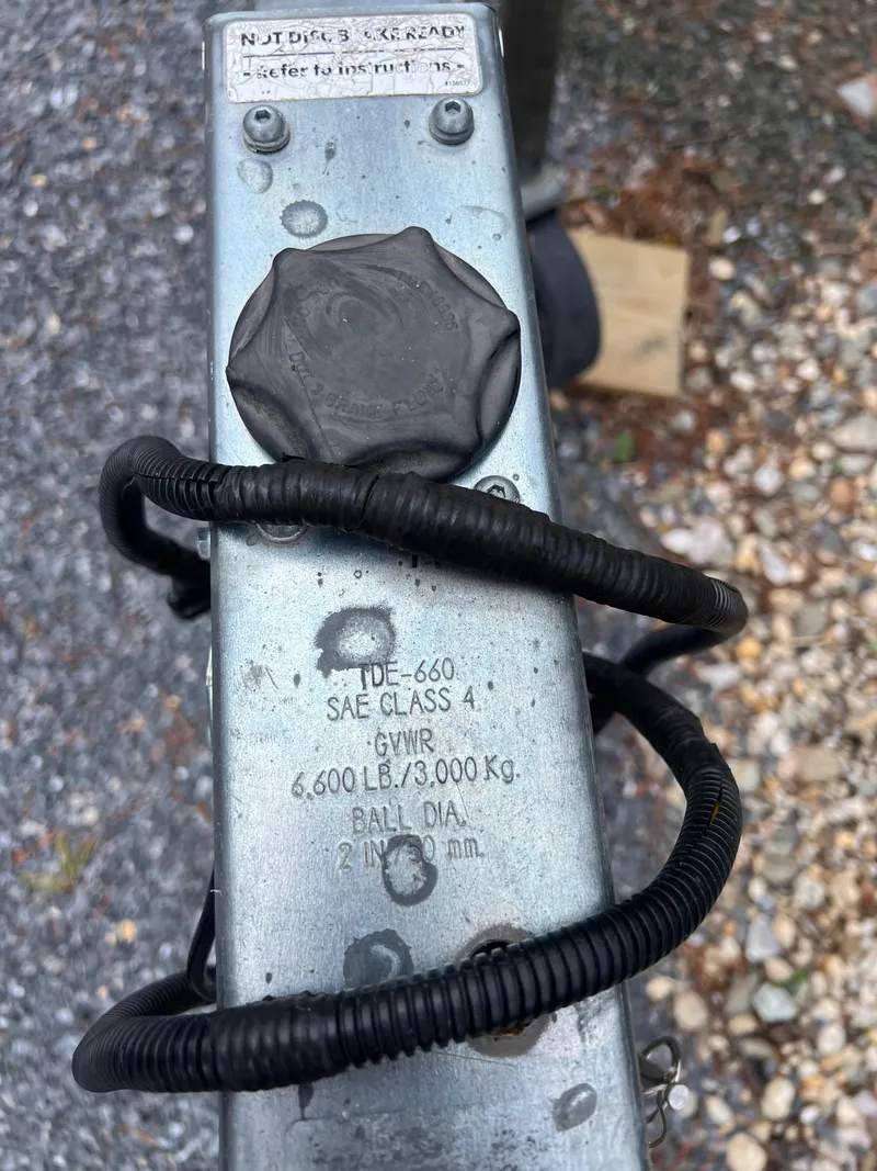 Slide: The Image of Trailer hitch with SAE Class 4 rating, 6,600 lbs capacity, coiled cable, gravel background. - 25