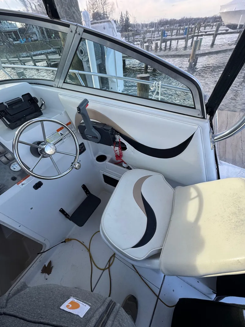 Slide: The Image of 2003 Seaswirl Striper 2301 Walkaround OB helm with steering wheel and seat, dockside view. - 5