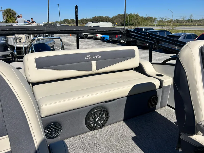 Slide: The Image of 2022 Barletta C24UC pontoon boat interior with beige seating and speaker system. - 4