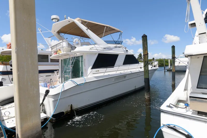 Slide: The Image of 1995 Sea Ray 500 Sedan Bridge yacht docked in a marina under clear blue skies. - 0