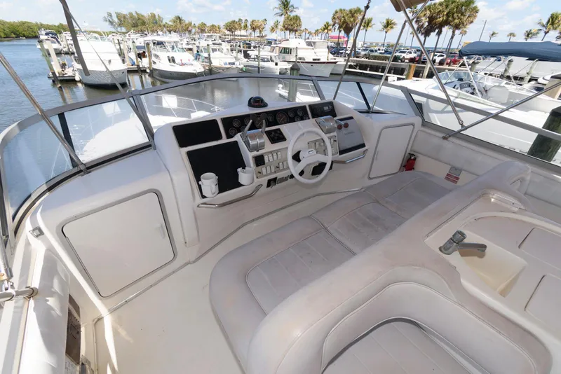 Slide: The Image of 1995 Sea Ray 500 Sedan Bridge helm with steering wheel and controls, docked at marina. - 10