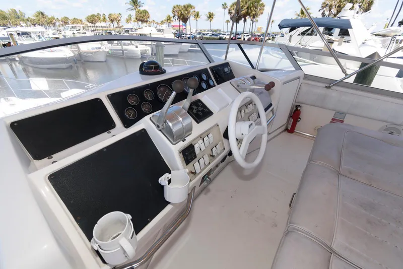 Slide: The Image of 1995 Sea Ray 500 Sedan Bridge helm with controls and seating, docked at marina. - 11