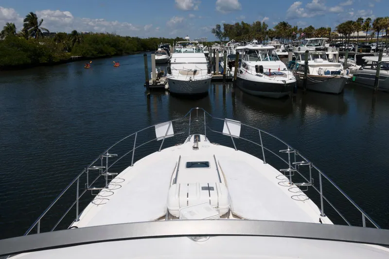 Slide: The Image of 1995 Sea Ray 500 Sedan Bridge yacht docked in a marina, surrounded by other boats. - 14