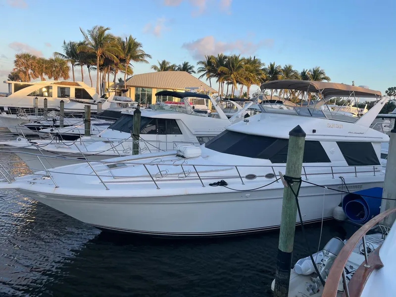 Slide: The Image of 1995 Sea Ray 500 Sedan Bridge yacht docked at marina with palm trees. - 2