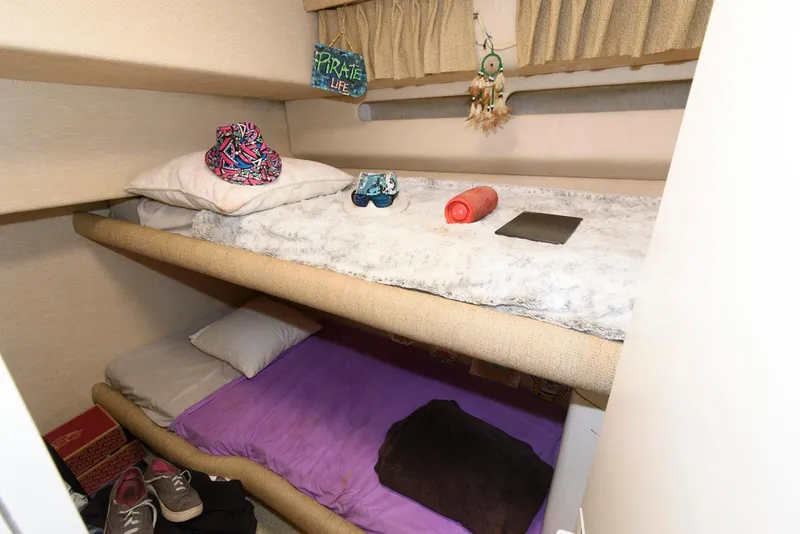 Slide: The Image of Bunk beds in 1995 Sea Ray 500 Sedan Bridge cabin with personal items and decor. - 24