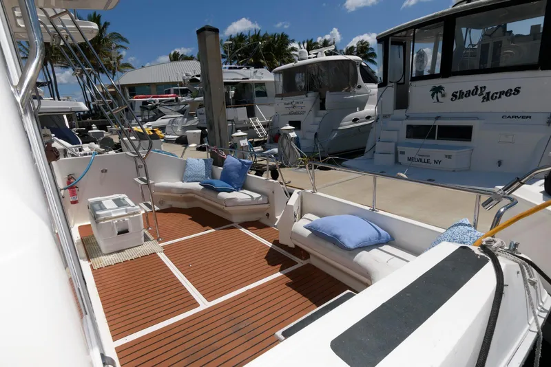 Slide: The Image of 1995 Sea Ray 500 Sedan Bridge yacht with spacious deck, cushioned seating, and marina view. - 7