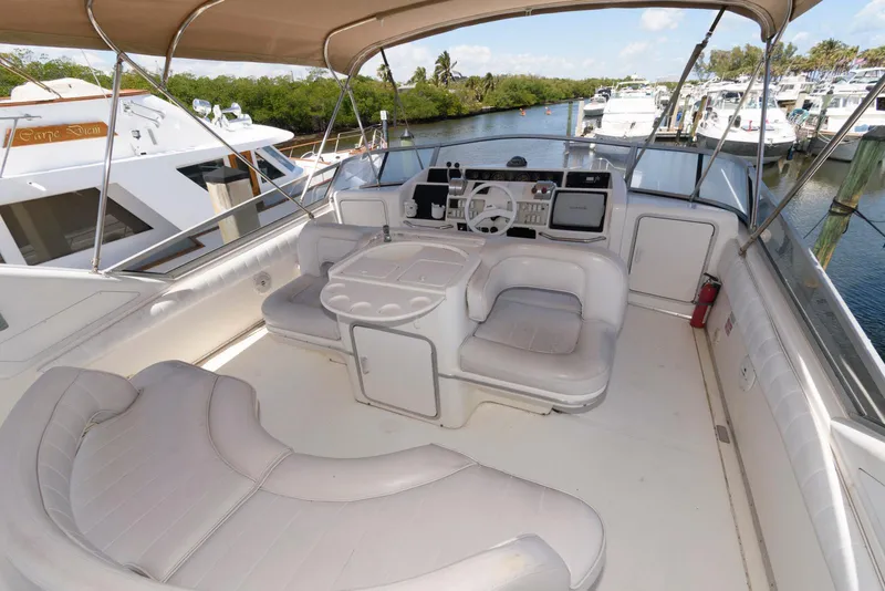 Slide: The Image of 1995 Sea Ray 500 Sedan Bridge yacht interior with seating and helm, docked at marina. - 9