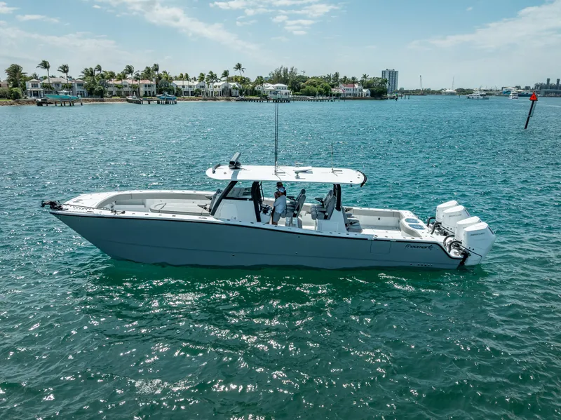 Slide: The Image of 2024 Freeman 43 boat cruising on clear blue water near a coastal town. - 11