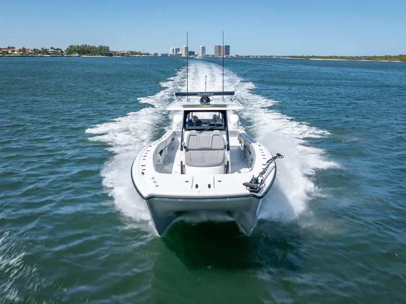 Slide: The Image of 2024 Freeman 43 boat cruising on open water, cityscape in background. - 14